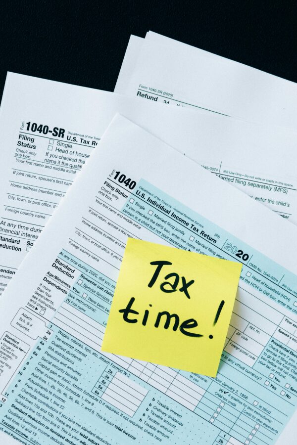 Home IRS 1040 tax forms with handwritten 'Tax Time!' note for filing reminder.